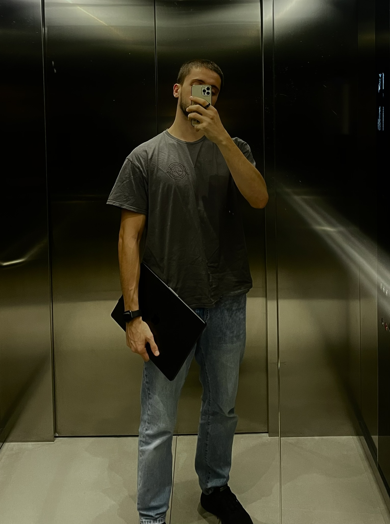 Massimo Stefan standing in an elevator, holding a laptop